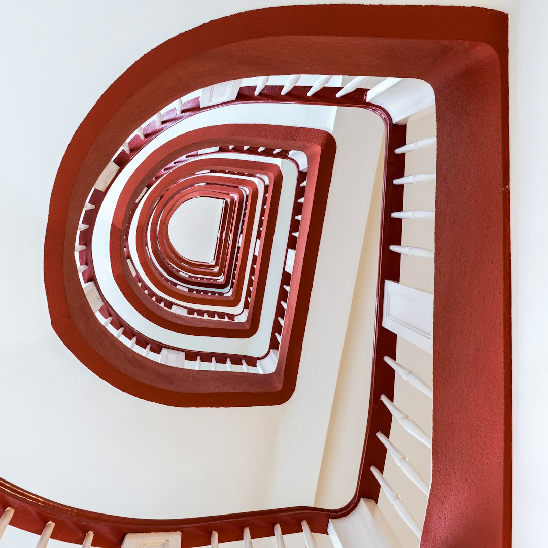 A spiral staircase in a building with a red and white design